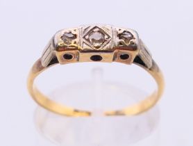 An 18 ct gold Art Deco three stone diamond ring. Ring size P.