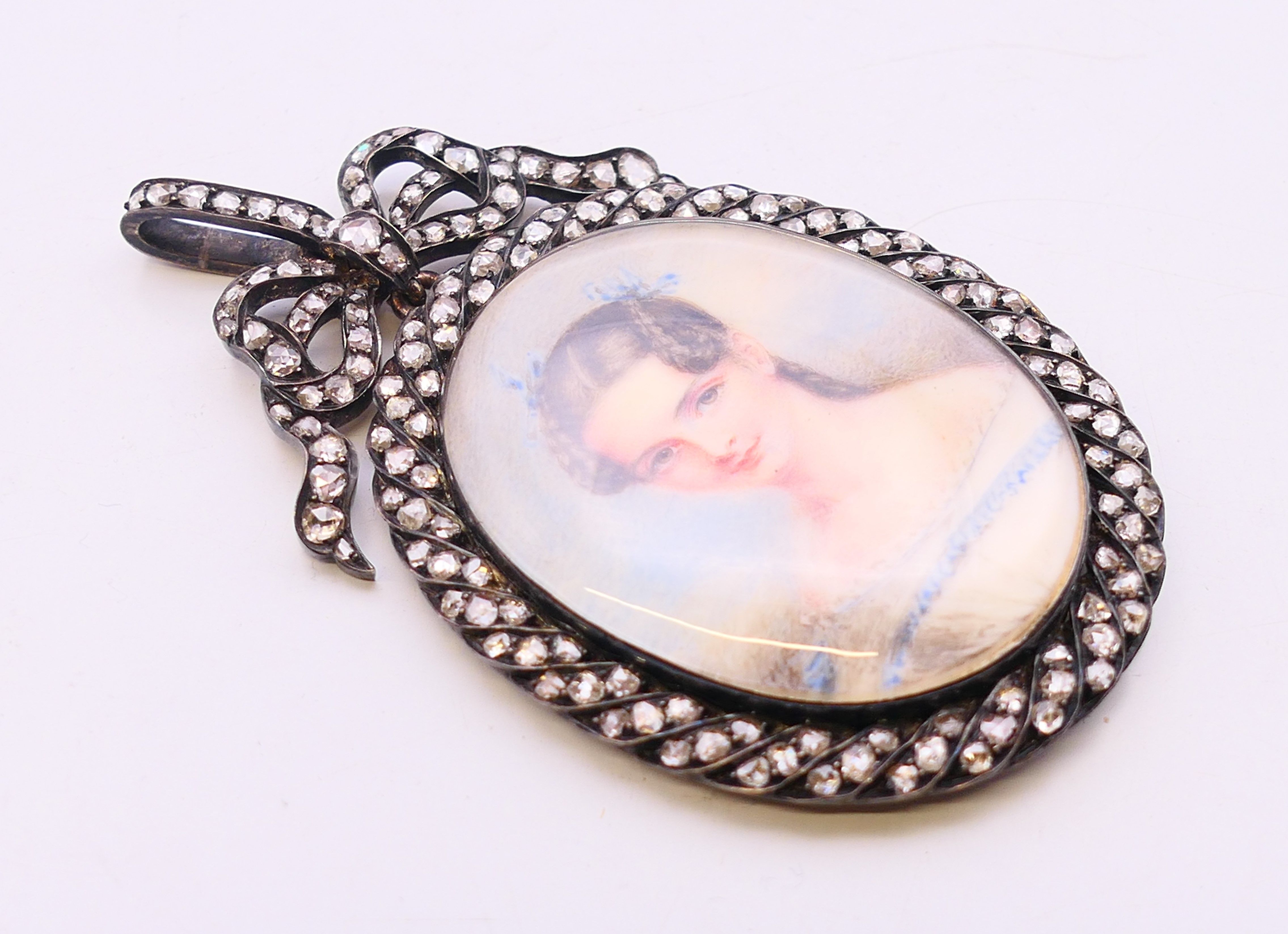 A 19th century portrait miniature on ivory of a lady a diamond set frame with bow tied swag and - Image 2 of 4
