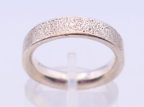 A silver wedding band stamped 925. Ring size L.