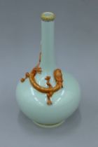 A Chinese celadon ground porcelain bottle vase decorated with a dragon. 30 cm high.