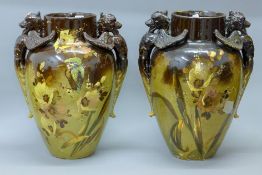 A pair of late 19th century florally-painted pottery vases, each with twin dragon handles.