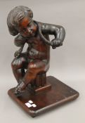 A 19th century carved wooden putto mounted on a later stand. 53 cm high.