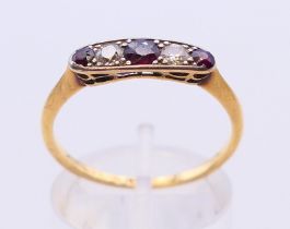 An 18 ct gold ring with three rubies and two diamonds. Ring size P.