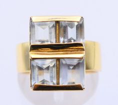 An 18 ct gold, aquamarine four stone ring, the emerald cut aquamarines 6 x 5mm x 3.9mm. Ring size O.