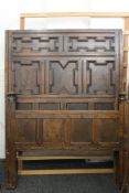 A 17th/18th century carved oak bed. 135 cm wide x 182 cm high.