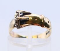 A 9 ct gold small buckle ring, ring size M/N.