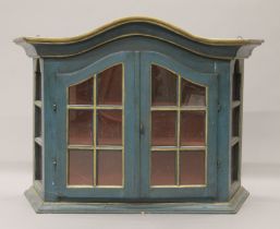 A green painted glazed wall cabinet. 91 cm wide.