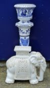 A blue and white porcelain jardiniere on stand, a porcelain elephant and a jardiniere stand.