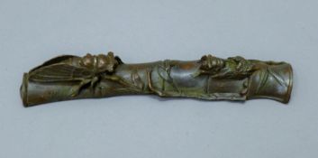 A bronze scroll weight. 16.5 cm long.