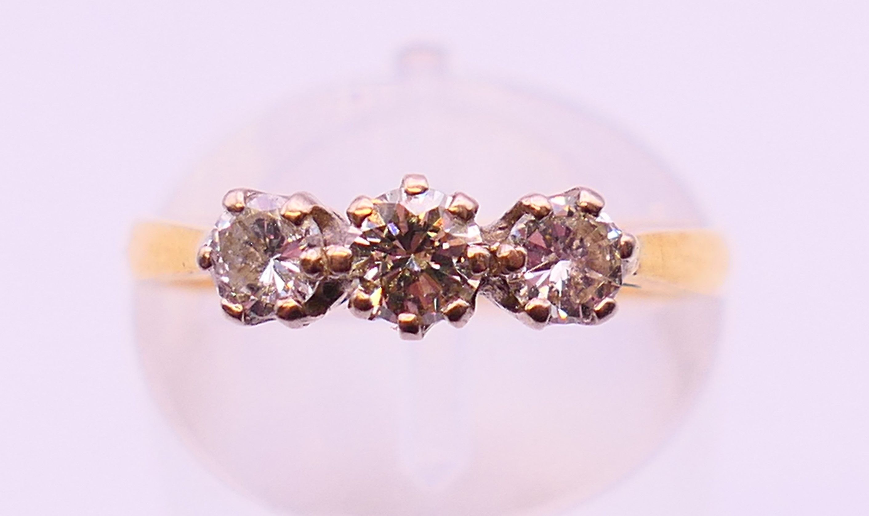 An 18 ct gold three stone diamond ring, hallmarked for London. Ring size L.
