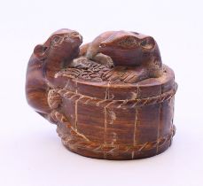 A hardwood netsuke in the form of rats on a barrel. 3 cm high.