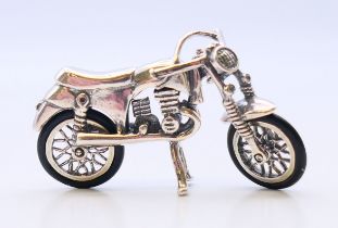 A silver miniature motorbike. 4.5 cm x 3 cm.