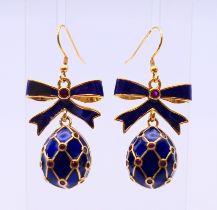 A pair of enamel egg and bow earrings, bearing Russian marks. 3 cm high excluding suspension loop.