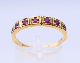 An 18 ct gold ruby set half eternity ring. Ring size S.