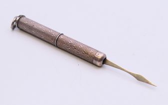 A silver tooth pick. 7 cm long extended.