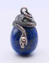 A silver lapiz egg pendant with entwined snake. 3 cm high.