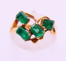An 18 ct gold four stone emerald ring. Ring size K.