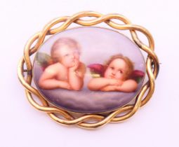 A 19th century painted porcelain mourning brooch decorated with two cherubs. 6.5 cm wide.