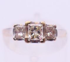 A 14 ct white gold three stone square diamond ring. Ring size L.
