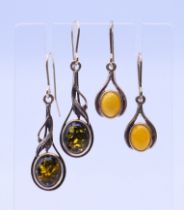 Two pairs of silver and amber earrings. Largest 3 cm high excluding suspension loop.