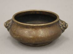 A small 18th/19th century Chinese bronze circular censer of squat form with two dog head bosses and