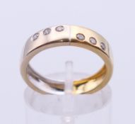 An 18 ct bi-colour gold and diamond ring. Ring size M. 4 grammes total weight.