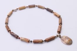A Canadian Jasper and Rhyolite pendant necklace. 40 cm long.