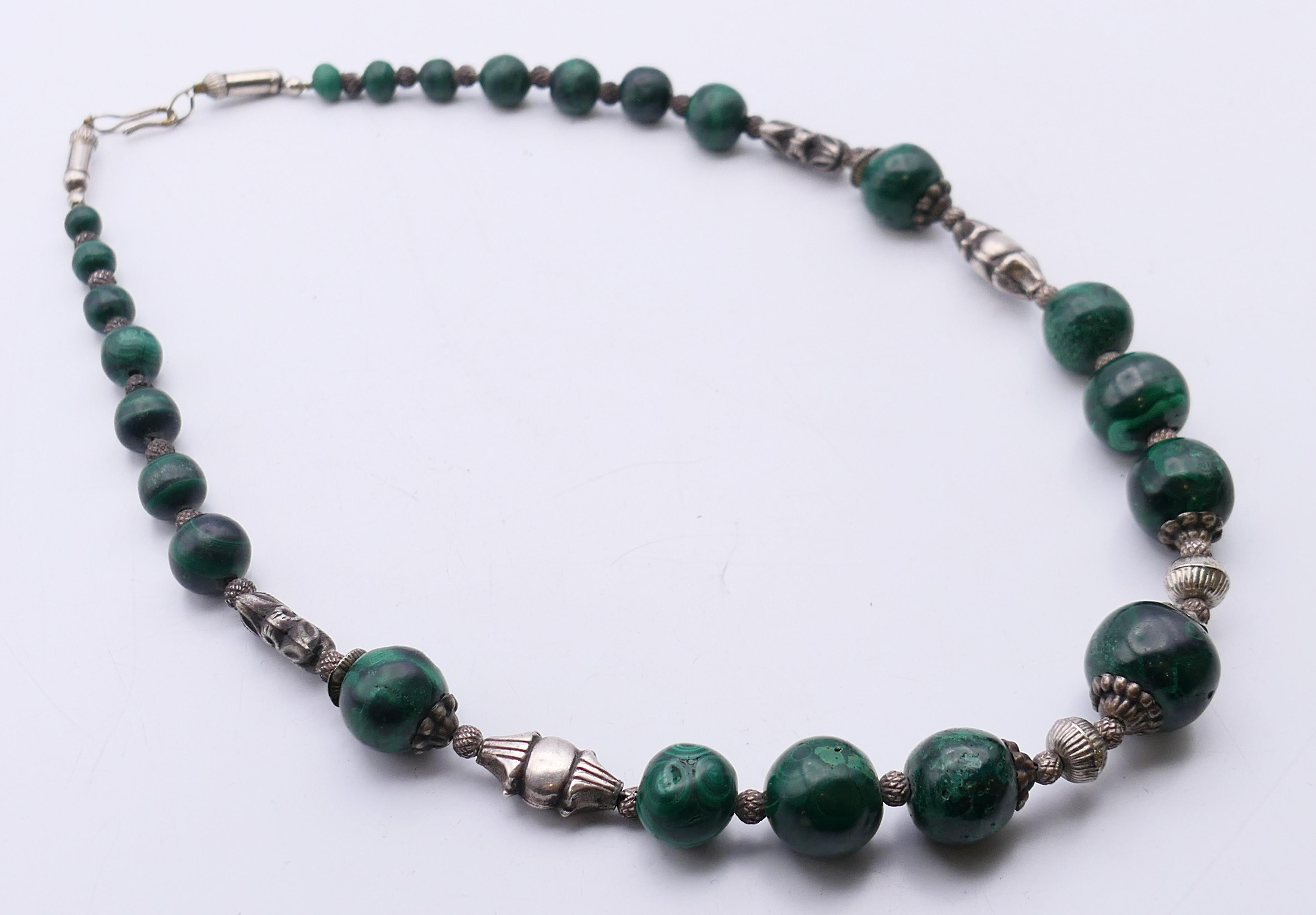 A white metal and malachite necklace. 51 cm long.