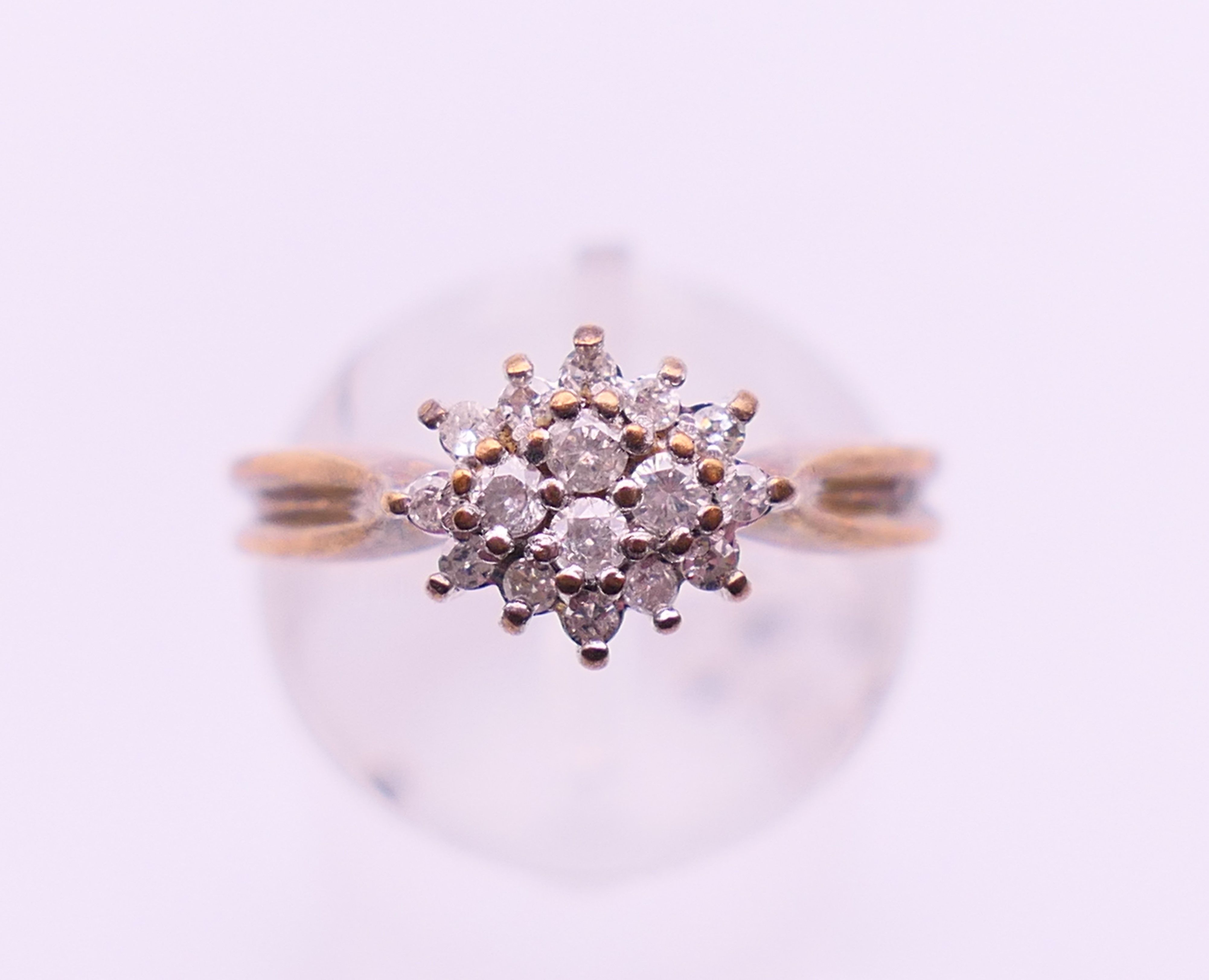A 9 ct gold and diamond cluster ring. Ring size N/O.