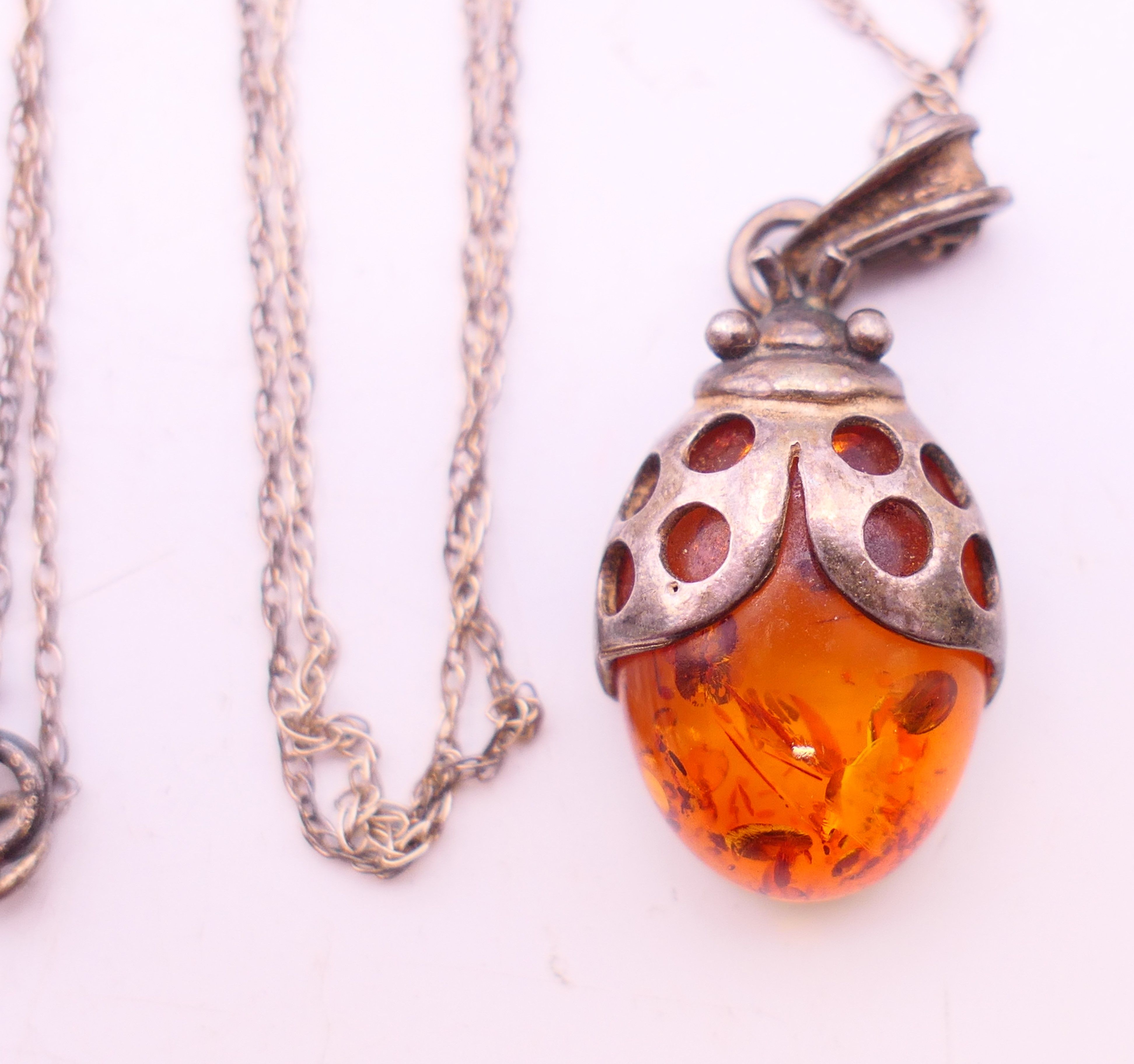 Four silver and amber items of jewellery. The largest pendant 5 cm high. - Image 4 of 11