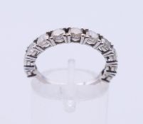 A 14 K white gold eleven-stone diamond ring (together with a gemological report). Ring size N.