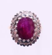 An 18 ct gold ruby and diamond cluster ring. Ring size O.