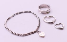 A Tiffany & Co silver bracelet, a ring and two heart pendants, in a Tiffany & Co box.