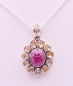 A silver rough cut diamond and ruby pendant on chain. The pendant 2.5 cm high.