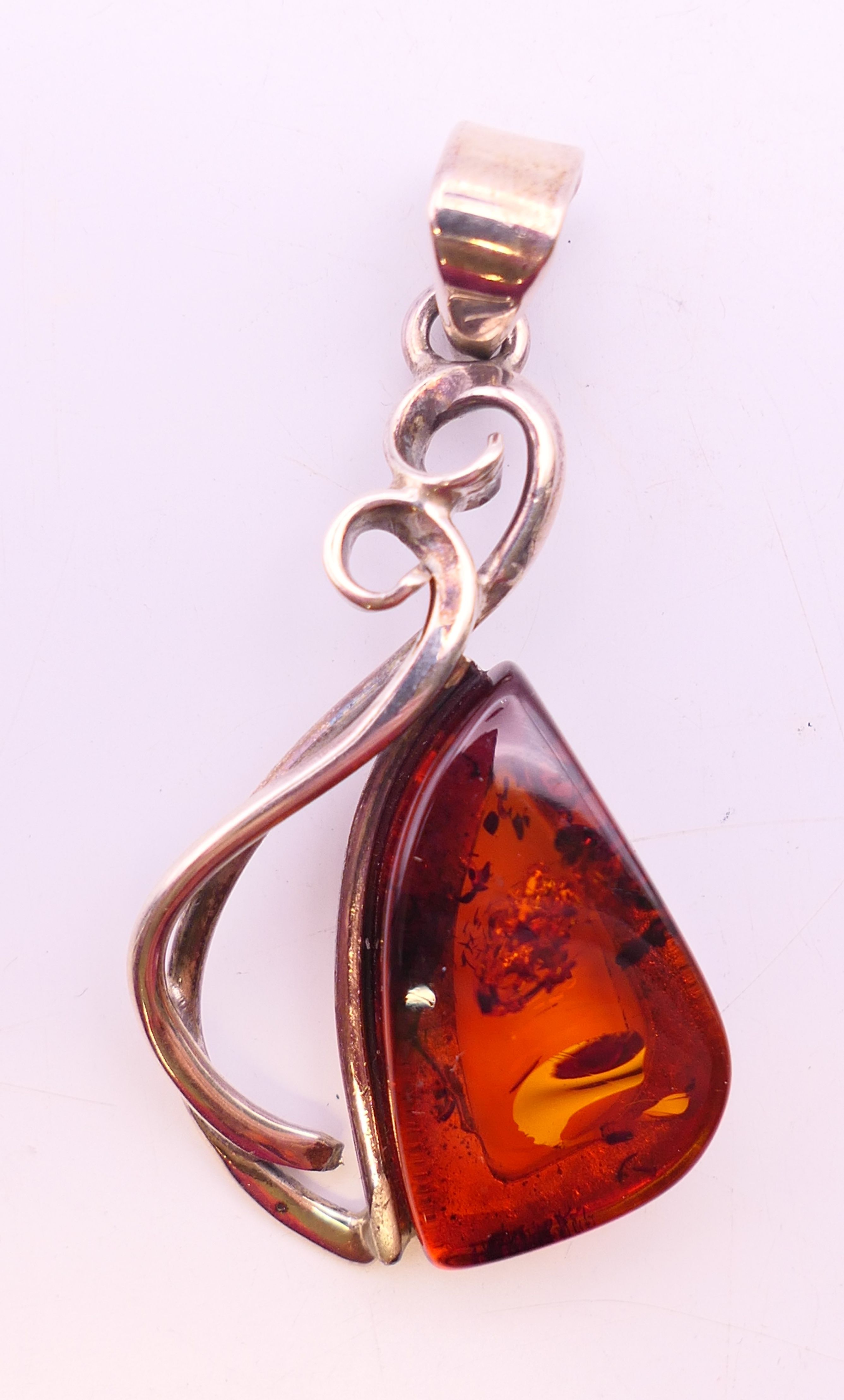 Four silver and amber items of jewellery. The largest pendant 5 cm high. - Image 2 of 11