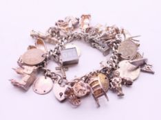 A silver charm bracelet. 16 cm long. 135.7 grammes total weight.