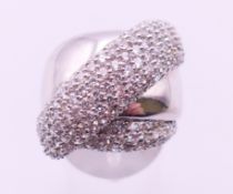 A silver and cubic zirconia crossover ring. Ring size L.