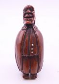 A carved coquilla nut figural snuff box. 8.5 cm high.