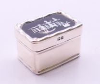 An Edwardian silver pill box, the lid with inlaid silver design on tortoiseshell,