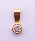 An 18 ct gold and diamond pendant. 1 cm high overall.