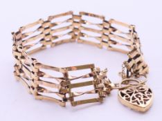 A 9 ct gold gate link bracelet with heart padlock. 18 cm long. 12.
