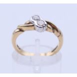 A 9 ct gold two-stone diamond crossover ring. Ring size K/L.