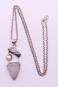 A silver and multi-stone abstract pendant on a silver chain. Pendant 5 cm high, chain 52 cm long.