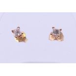 A pair of 18 ct gold princess cut diamond stud earrings. 3 mm square.
