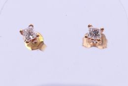 A pair of 18 ct gold princess cut diamond stud earrings. 3 mm square.