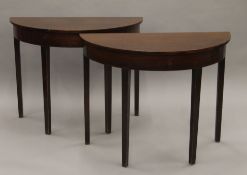 A pair of mahogany demi-lune side tables. 91 cm wide.