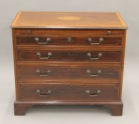 An Edwardian inlaid mahogany chest of drawers with brushing slide. 94 cm wide.