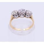An unmarked gold three-stone diamond ring. Ring size G.