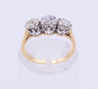 An unmarked gold three-stone diamond ring. Ring size G.