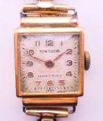 An 18 K gold cased Tonodor wristwatch with original fabric strap. 1.75 cm wide.9.